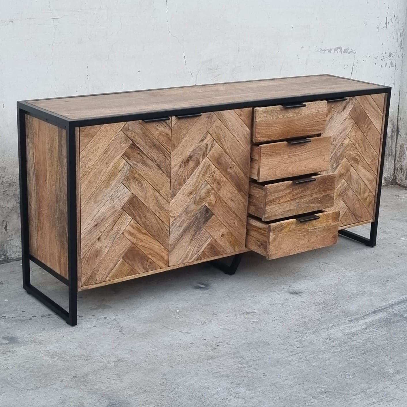 Ce buffet Herringbone style industriel Kukuu a été fabriqué à partir de bois massif de manguier et de métal. Il possède 4 tiroirs de rangement ainsi que 3 portes avec étagères et espaces de rangement. Mesures: 180 (L) x 46 (l) x 84 (H) cm. Kukuu, spécialiste en meubles industriels.