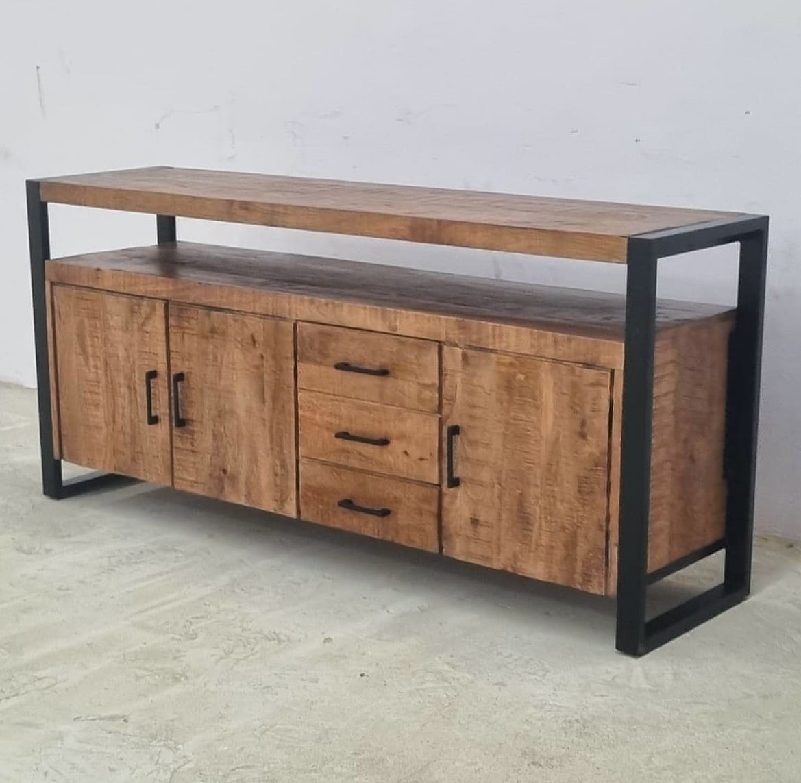 Ce buffet industriel 3 portes Kukuu a été fabriqué à partir de bois massif de manguier et de métal. Il possède 3 tiroirs de rangement ainsi que 3 portes avec étagères. Mesures: 175 (L) x 45 (l) x 80 (H) cm. Kukuu, meubles industriels de qualité.