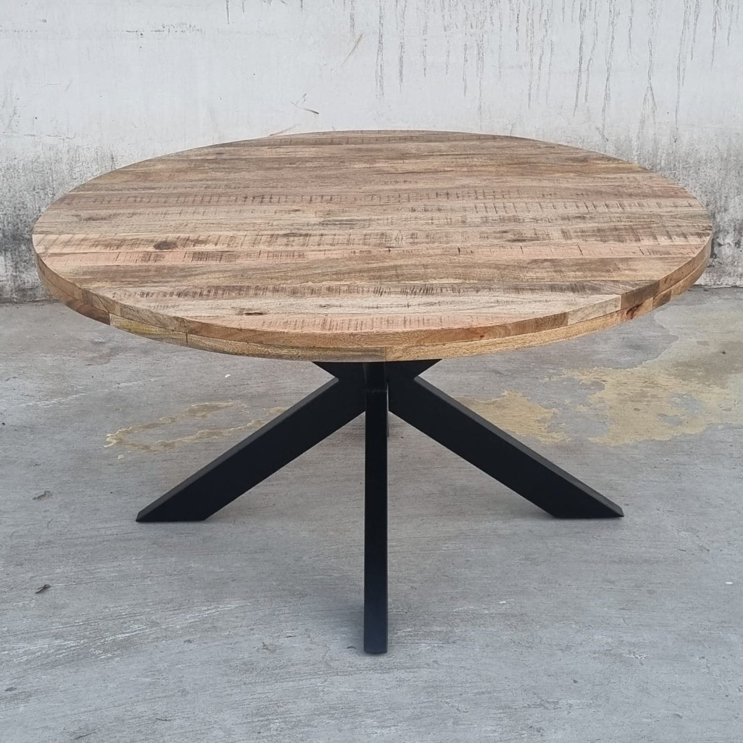 La table industrielle ronde Kukuu a été fabriquée à partir de pieds en métal et d'un plateau en bois massif de manguier. Mesures: 120 (L) x 120 (l) x 78 (H) cm. Kukuu, boutique en ligne de mobilier industriel.