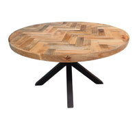 La table ronde herringbone a été fabriquée à partir d'une base en métal et d'un bois en bois massif de manguier. Mesures: 140 (L) x 140 (l) x 78 (H) cm. Kukuu, meubles industriels de qualité.