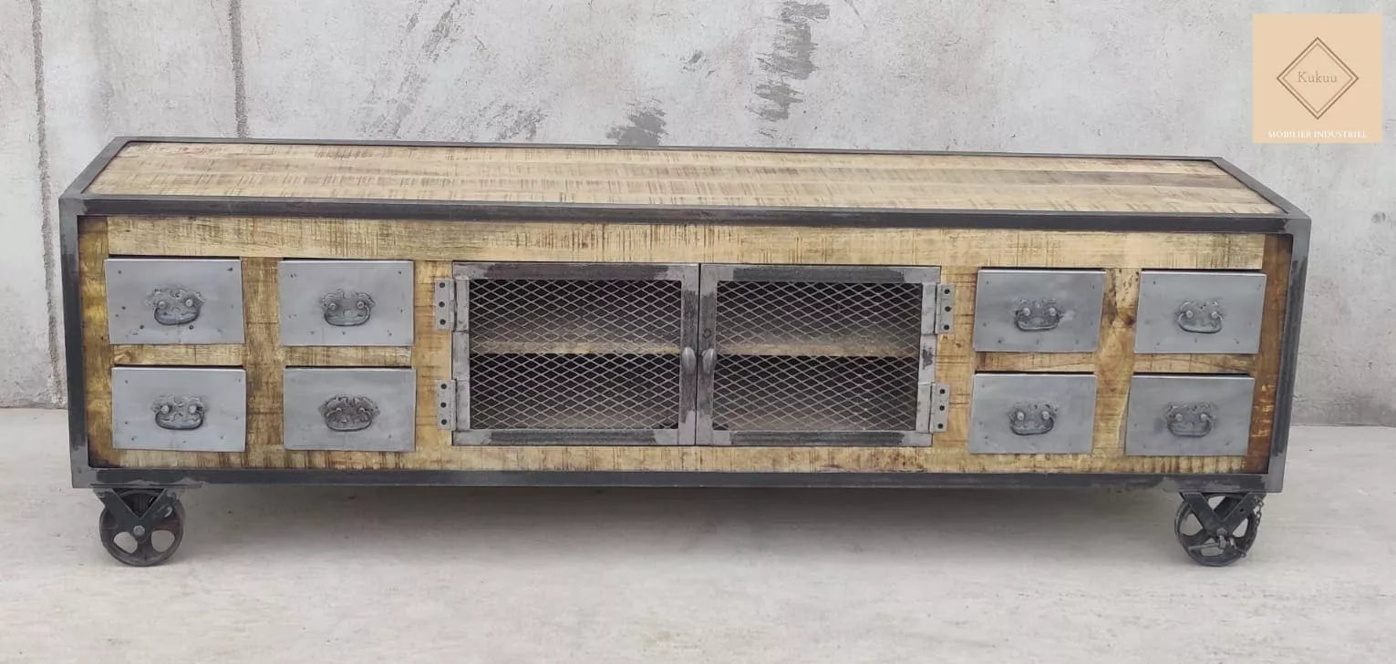 Ce meuble tv industriel à roulettes a été fabriqué à partir d'une structure en bois massif de manguier et d'éléments en métal.  Il est composé de huit tiroirs métalliques et de deux portes centrales grillagées. Dimensions: 180 (L) X 45 (l) X 55 (H) cm. Kukuu, boutique en ligne de mobilier industriel et bois massif de qualité supérieur.