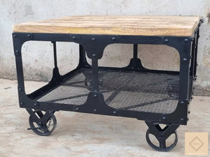 Cette table basse industrielle à roulettes est faite de bois de manguier sur une base métallique. Mesures: 70 x 70 x 48 cm. Kukuu, boutique en ligne de mobilier industriel, vintage et scandinave. Mobilier jardin.